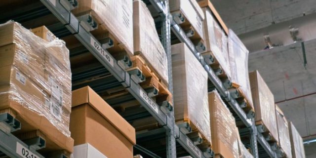 A warehouse showcasing organized shelves with stacked cardboard boxes for storage and logistics.